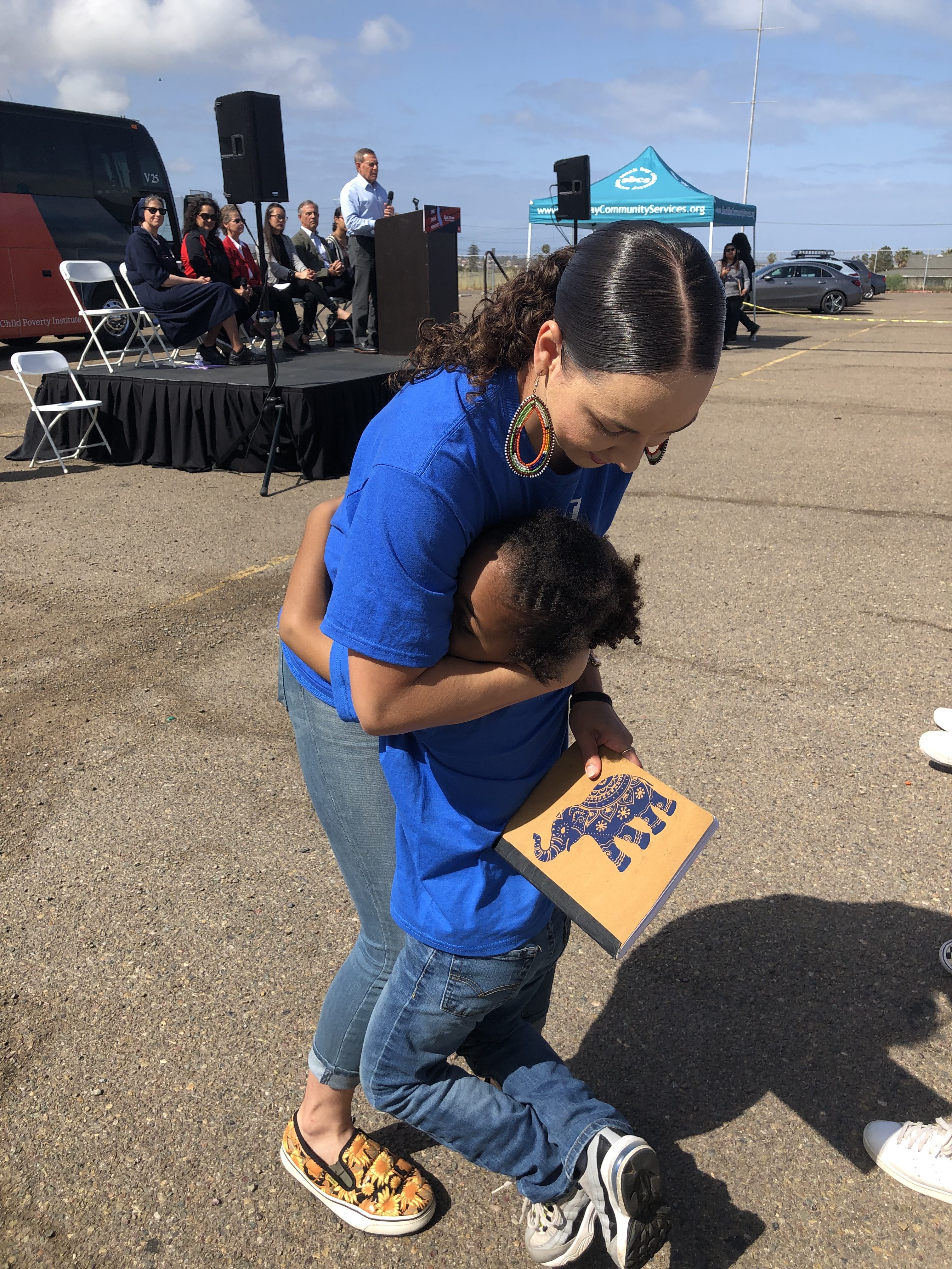 Parent Voices leader Monique gets a hug from her son Makai after speaking in Chula Vista, CA